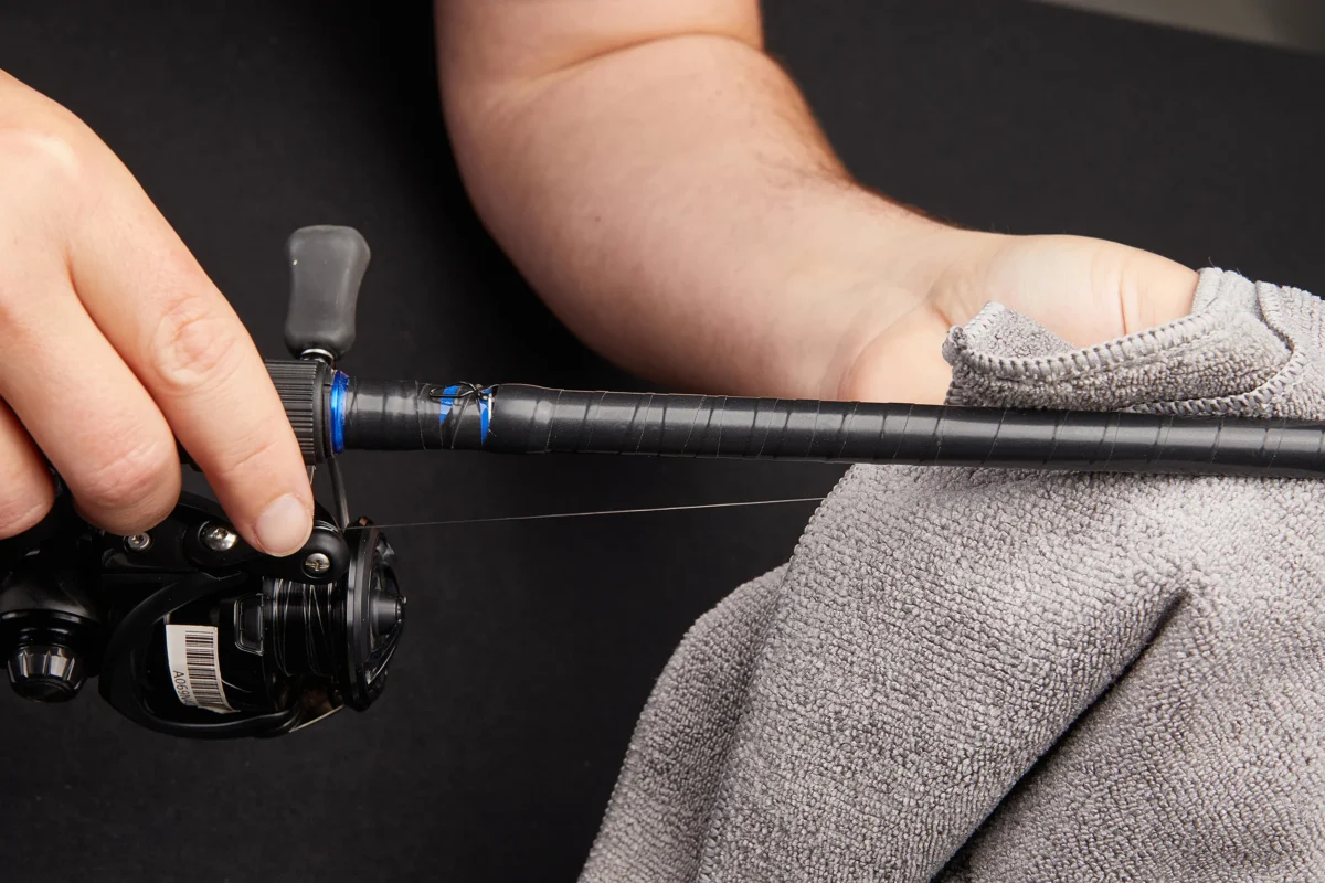 Spooling fishing reel under tension with cloth