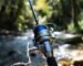 A balanced ultralight spinning reel and carbon fiber rod setup by a stream.