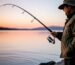 A fisherman demonstrating the perfect overhead cast with a spinning reel and carbon fiber rod.